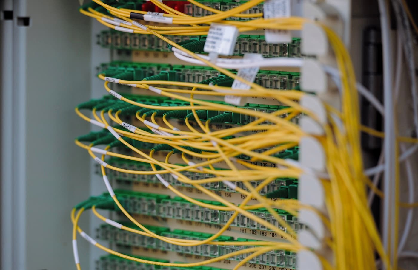 A network patch panel with yellow fibre-optic leads running to circuit boards.